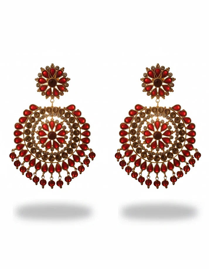 Close-up of Pakistani festive jhumka earrings featuring ruby red simulated stones, clear crystal accents, and dangling bead drops on gold-tone finish
