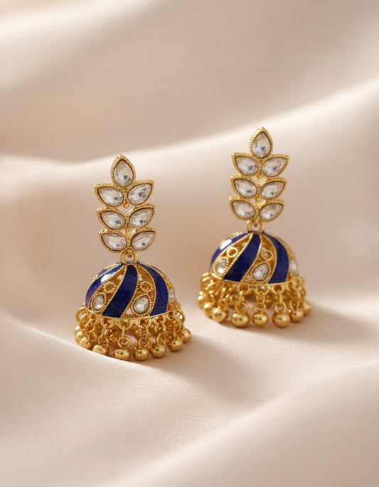 Pair of gold and blue earrings on a beige background