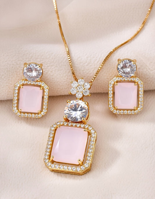Jewelry set with pink gemstones and gold accents on a beige background
