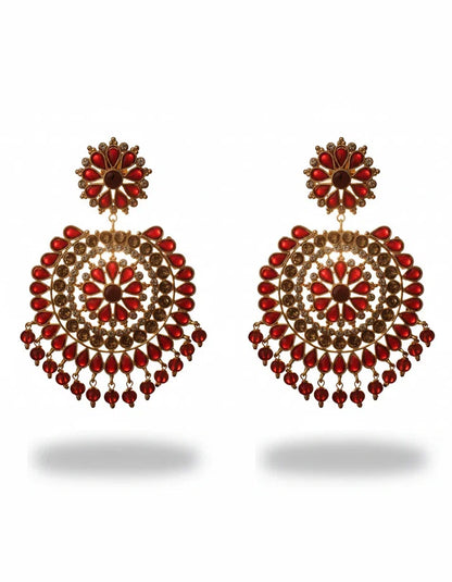 Close-up of Pakistani festive jhumka earrings featuring ruby red simulated stones, clear crystal accents, and dangling bead drops on gold-tone finish