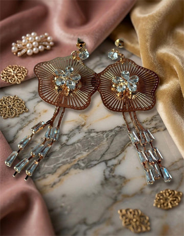 Ornate earrings with gemstones on a marble surface