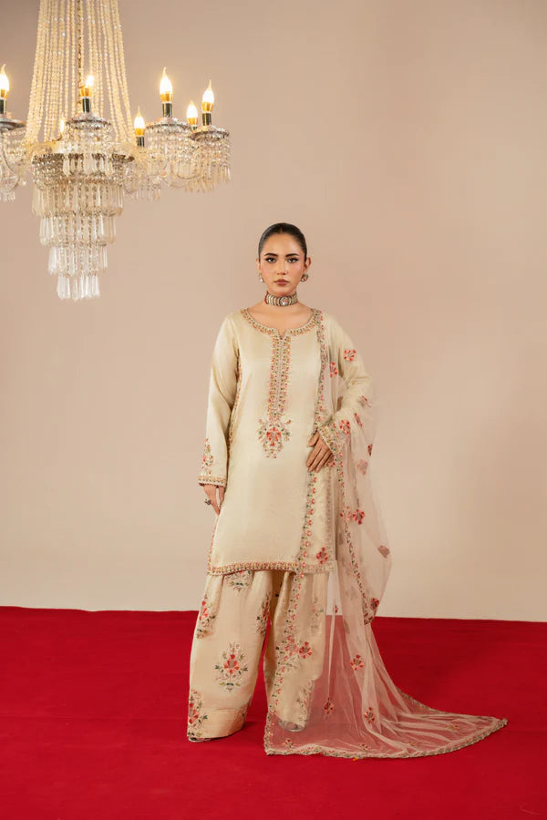Woman in a traditional outfit standing on a red carpet with chandeliers in the background