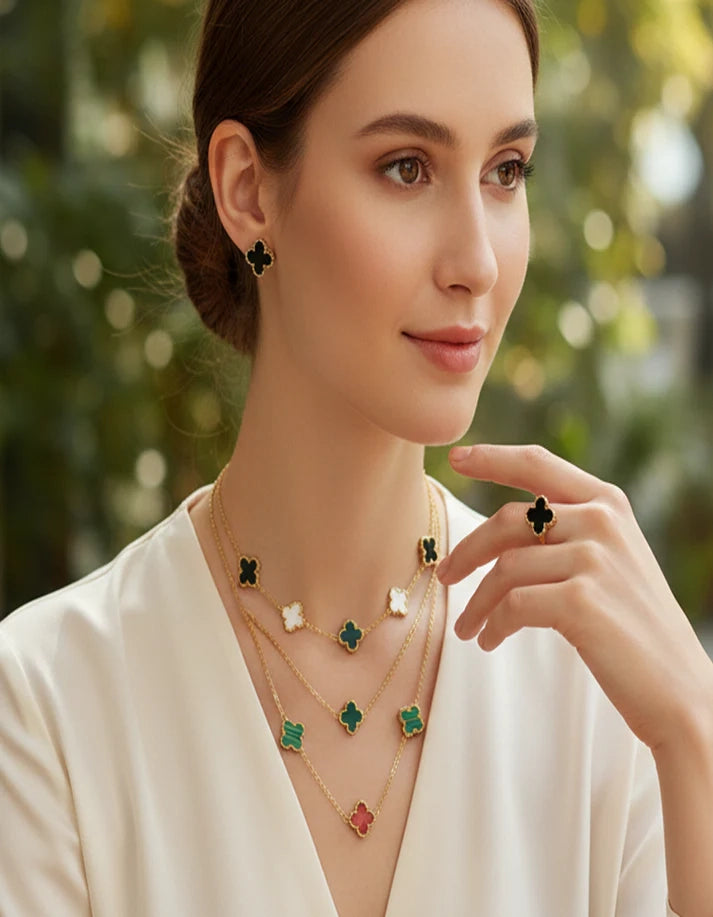 Woman wearing a necklace with green clover pendants against a blurred natural background
