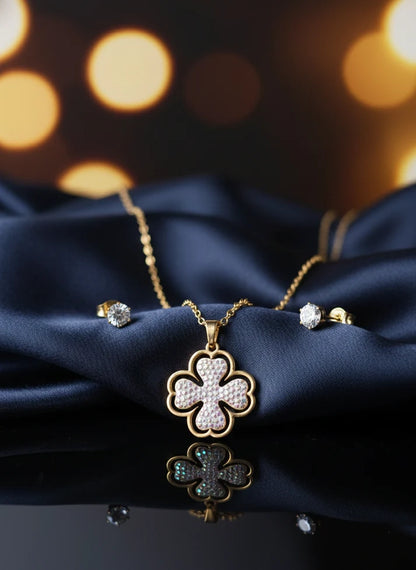 Gold necklace with clover design and matching earrings on a dark 