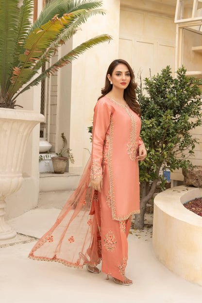 Woman in a peach traditional outfit standing in a garden setting
