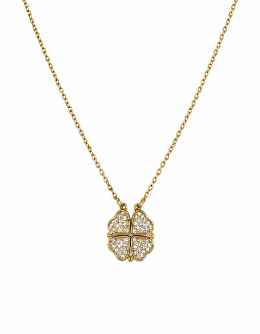 Gold necklace with a diamond-encrusted clover pendant on a white background