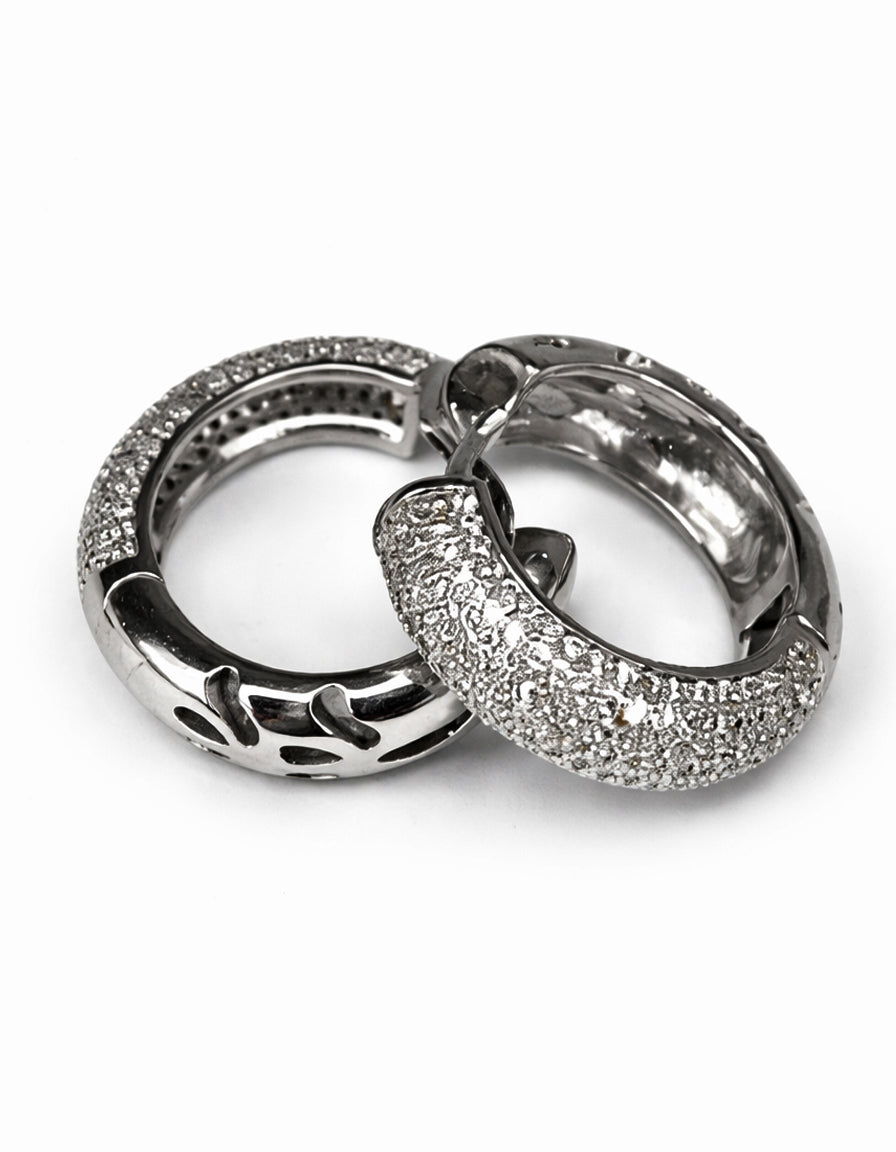 Pair of silver hoop earrings with clear gemstones on a white background