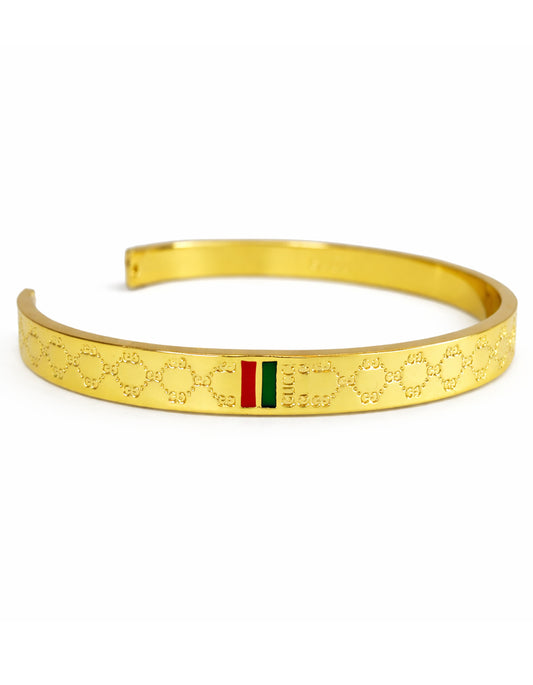 Gold bracelet with a green and red stripe on a white background