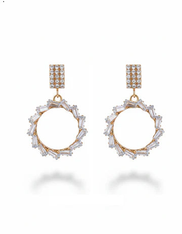 Gold and crystal hoop earrings on a white background