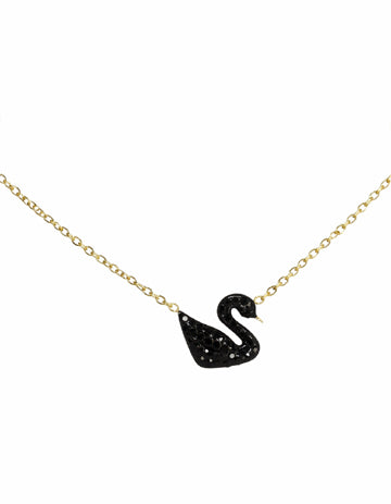 Black swan pendant necklace on a gold chain against a white background