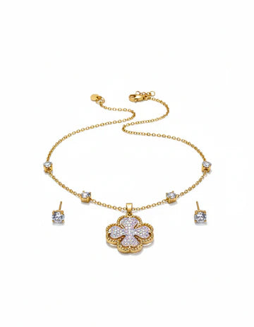 Gold necklace with floral pendant and matching earrings on a white background
