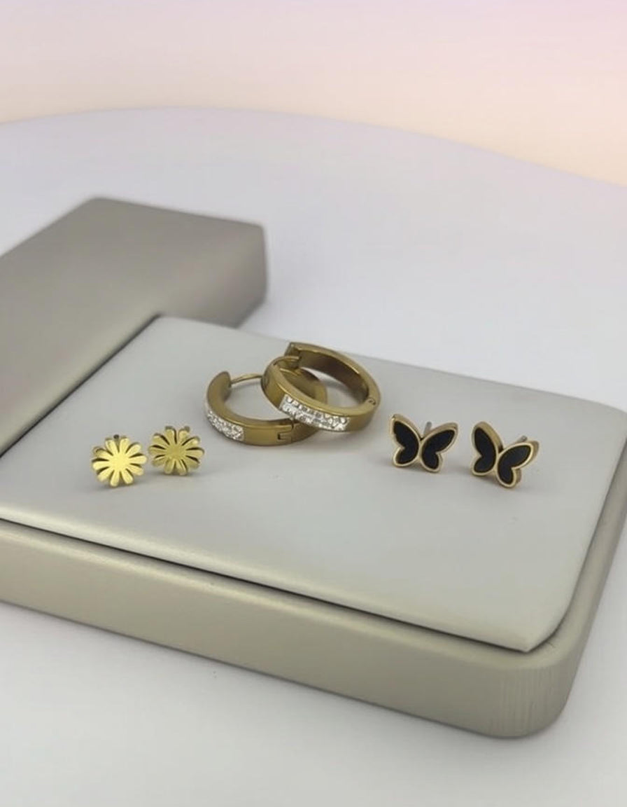Jewelry set with rings and earrings on a light gray surface