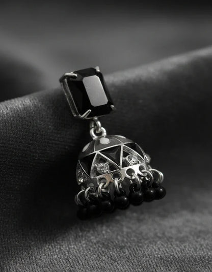 Jewelry pendant with a black gemstone on a textured surface