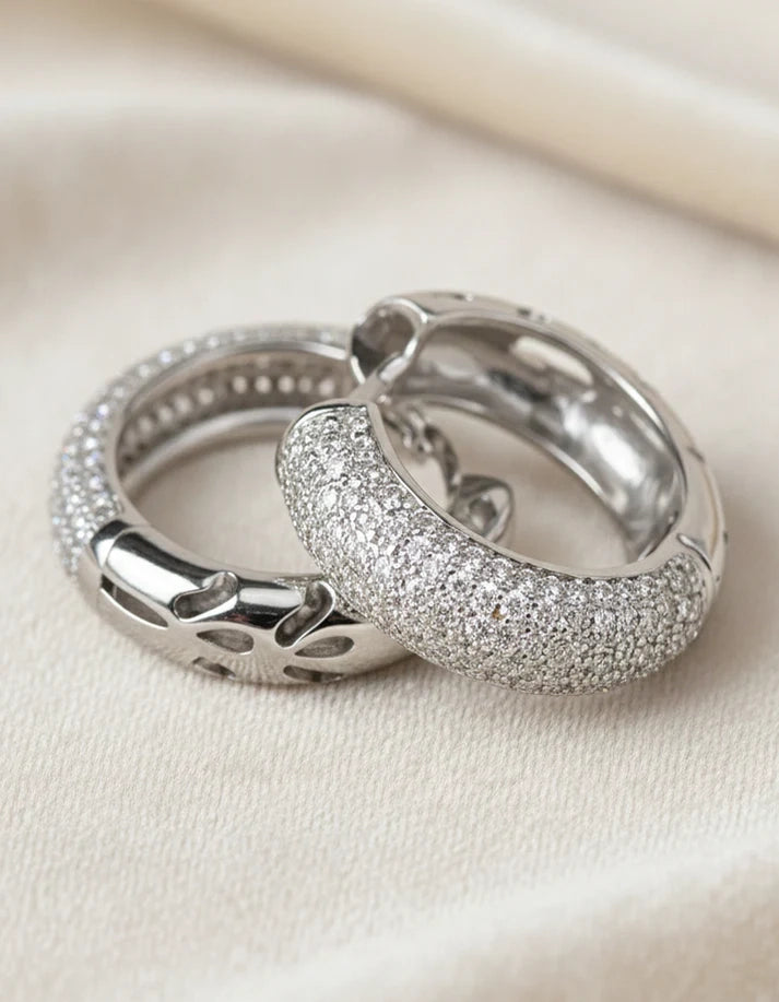Two silver rings with glittery texture on a light beige background