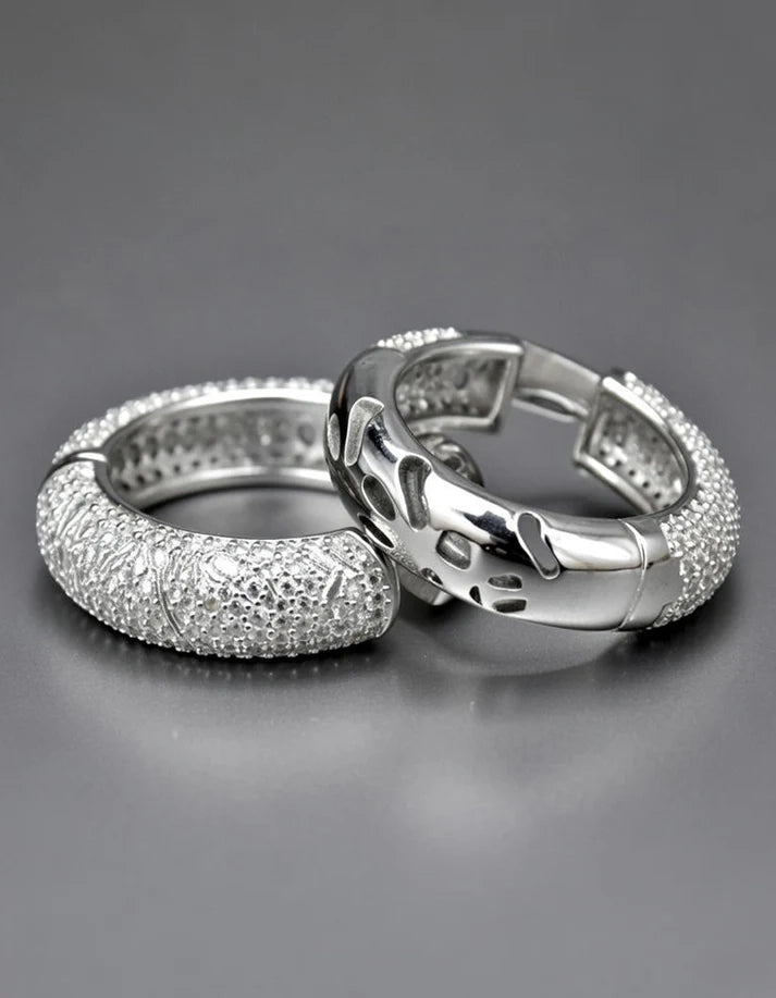 Two silver rings with diamond-like stones on a gray background