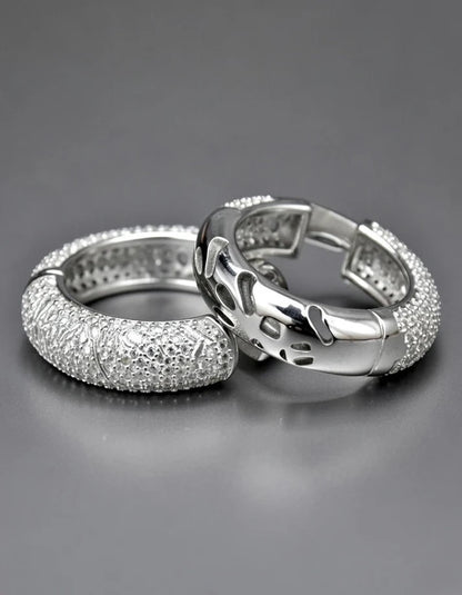 Two silver rings with diamond-like stones on a gray background