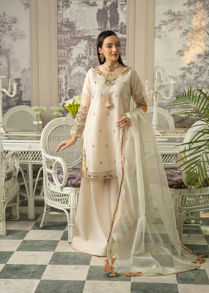 Woman in a traditional outfit standing in an elegant indoor setting with white furniture and decorative elements.