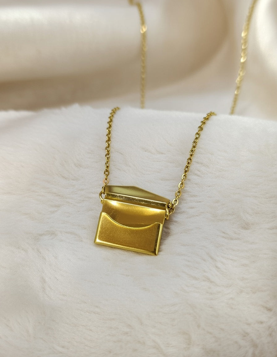 Gold necklace with a pendant on a white surface